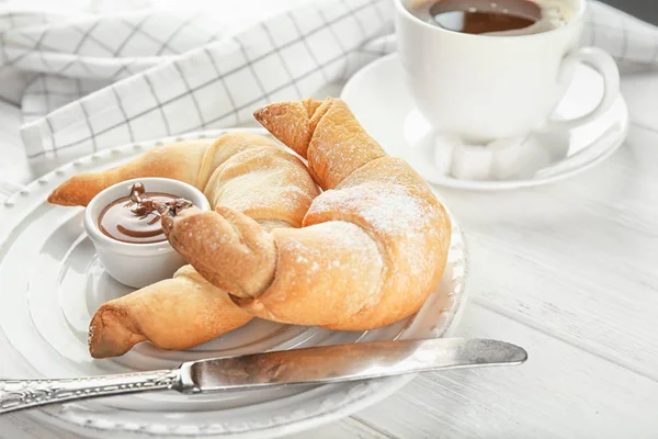 Tasty crescent rolls with chocolate sauce on plate, closeup — Stock Photo, Image