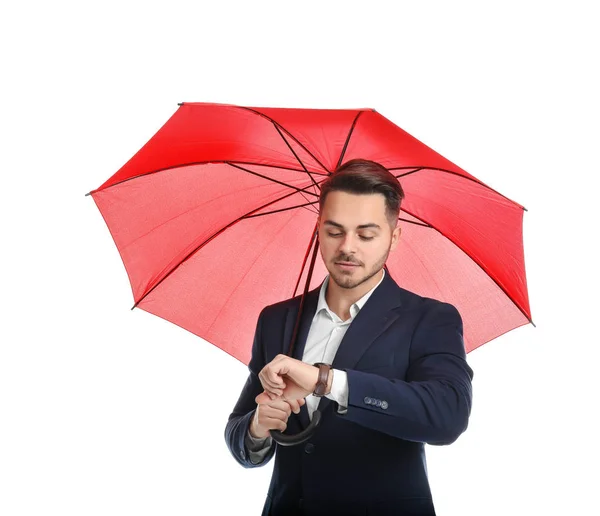 Joven en traje elegante con paraguas rojo sobre fondo blanco —  Fotos de Stock