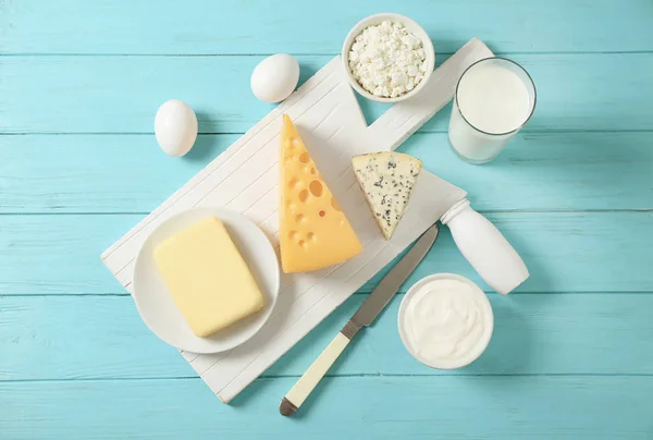 Fresh dairy products and eggs on wooden background — Stock Photo, Image