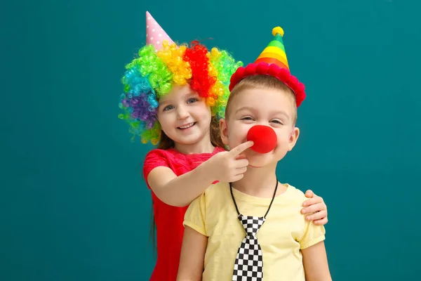 Cute little kids in funny disguise on color background. April fool's day celebration — Stock Photo, Image