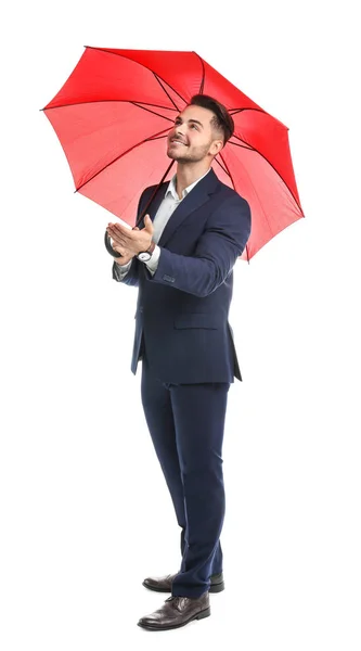 Joven en traje elegante con paraguas rojo sobre fondo blanco — Foto de Stock