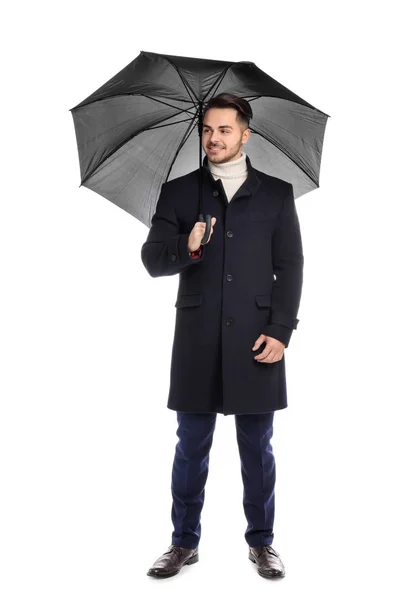 Jonge man met warme vacht met donkere paraplu op witte achtergrond — Stockfoto