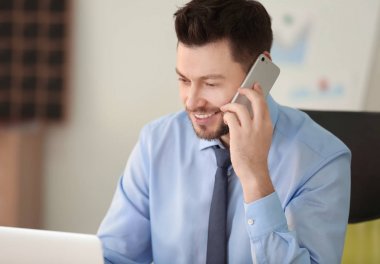 Genç adam iş yerinde konuşuyor.