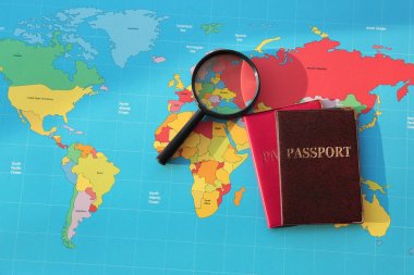 Magnifying glass, passports on world map. Immigration concept clipart