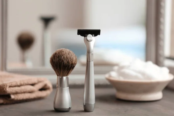 Кисть для бритья и бритва для человека на столе — стоковое фото