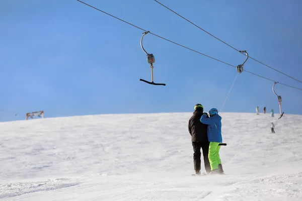 Toeristen met behulp van de skilift in het besneeuwde resort. Wintervakantie — Stockfoto