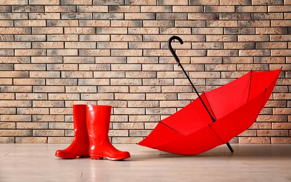 Красный зонтик и резиновые сапоги — стоковое фото