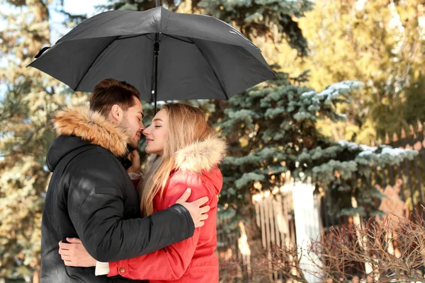Mladý romantický pár s deštníkem v parku — Stock fotografie