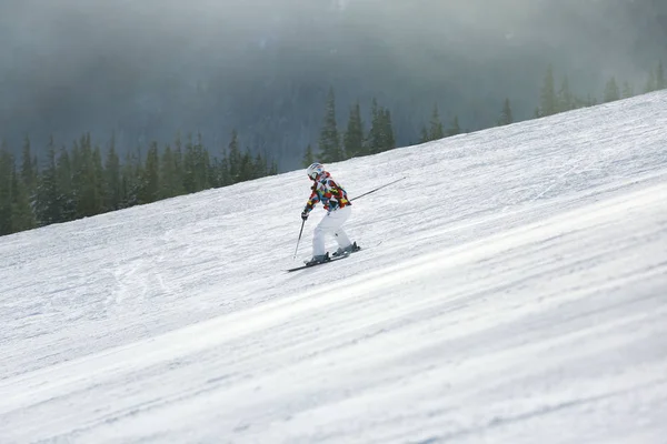 Mulher esquiando downhill no resort nevado. Férias inverno — Fotografia de Stock