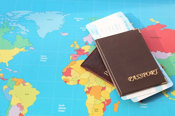 Pasaportes con tarjetas de llegada de la oficina de inmigración en el mapa del mundo — Foto de Stock