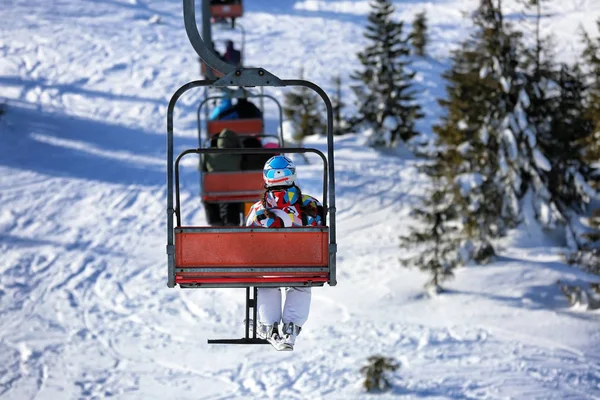 Kvinna på skidlift på snöiga resort. Vintersemester — Stockfoto