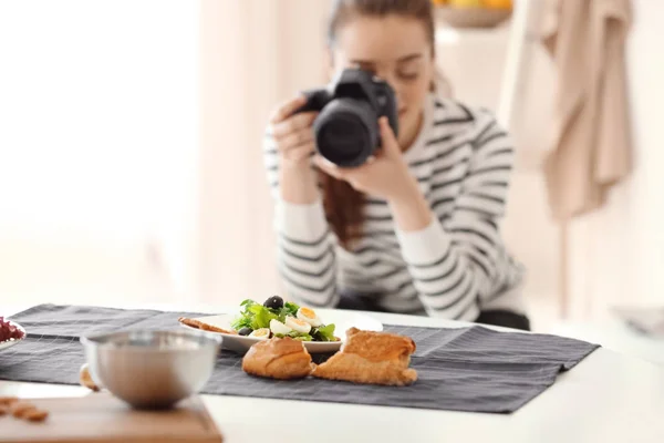 Mujer joven con cámara profesional tomando fotografías de naturaleza muerta. Centrarse en los alimentos —  Fotos de Stock