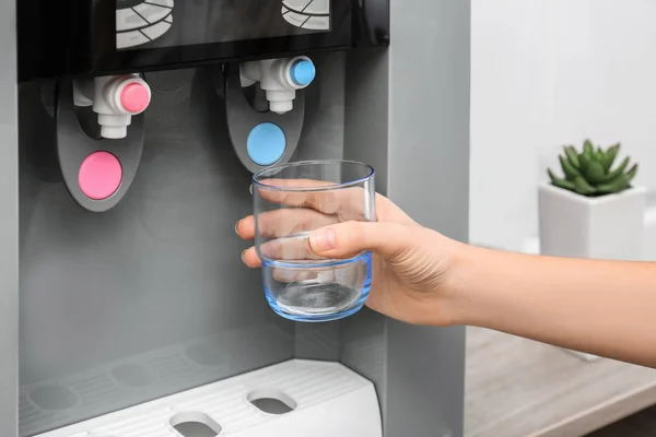 Vidro de enchimento da mulher do refrigerador de água, close-up — Fotografia de Stock