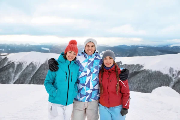 Glada vänner på snötäckta bergstopp — Stockfoto