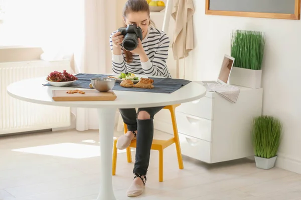 Mujer joven con cámara profesional tomando fotos de naturaleza muerta en el interior —  Fotos de Stock