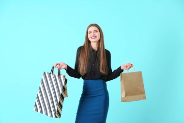 Arkaplanda alışveriş torbaları olan güzel genç bir kadın.