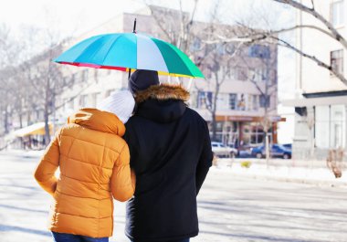 Şehir sokak üzerinde renkli şemsiye ile genç Romantik Çift
