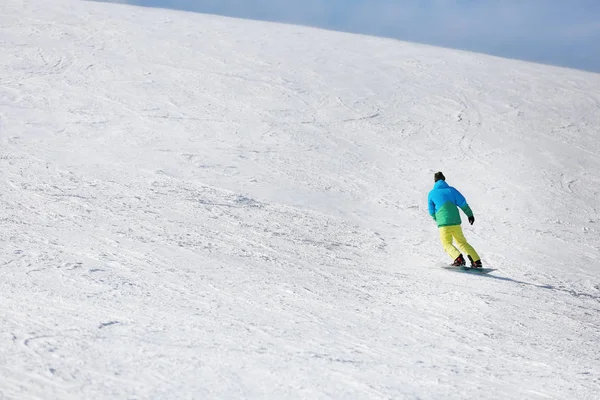 Snowboarder op de skipiste in het besneeuwde resort. Wintervakantie — Stockfoto