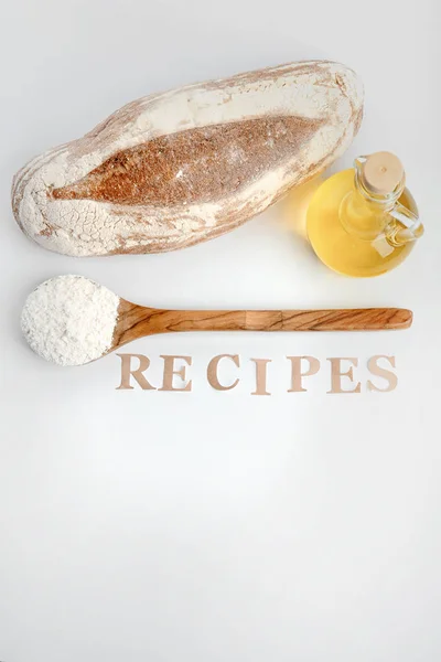 Komposition mit frisch gebackenem Brot, Öl und Mehl auf weißem Hintergrund — Stockfoto