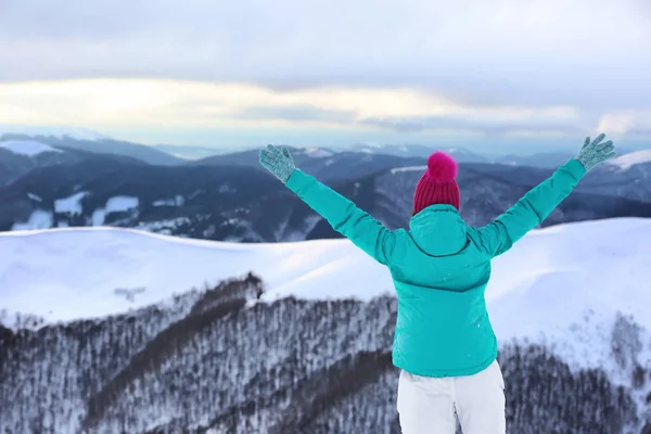 Vrouw genieten van de schoonheid van de besneeuwde berg — Stockfoto