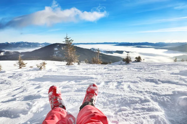 Legs of tourist on snowy resort. Winter vacation — Stock Photo, Image