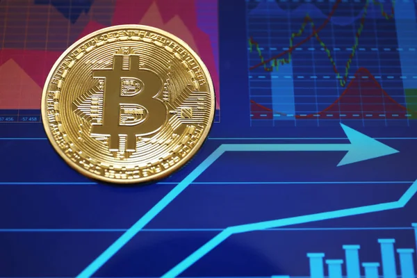 Golden bitcoin on screen with chart — Stock Photo, Image