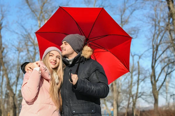 Jeune couple romantique avec parapluie lumineux le jour ensoleillé d'hiver — Photo