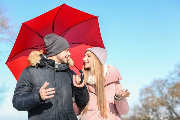 Mladý romantický pár s světlé deštník na slunný zimní den — Stock fotografie