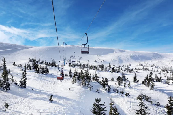 Skilift mit Touristen im verschneiten Skigebiet. Winterurlaub — Stockfoto