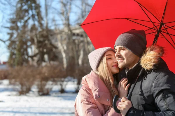 Młody romantyczny para z jasne parasol słoneczny zimowy dzień — Zdjęcie stockowe