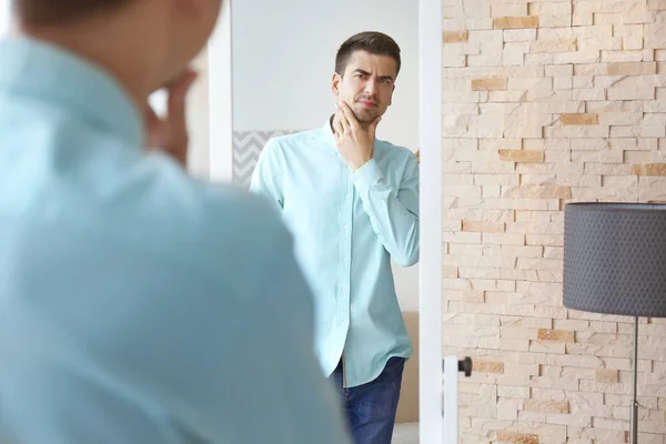 Handsome man looking in mirror — Stock Photo, Image