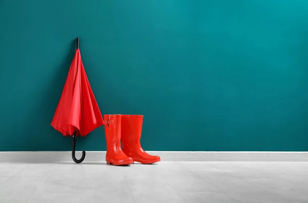 Красный зонтик и резиновые сапоги — стоковое фото