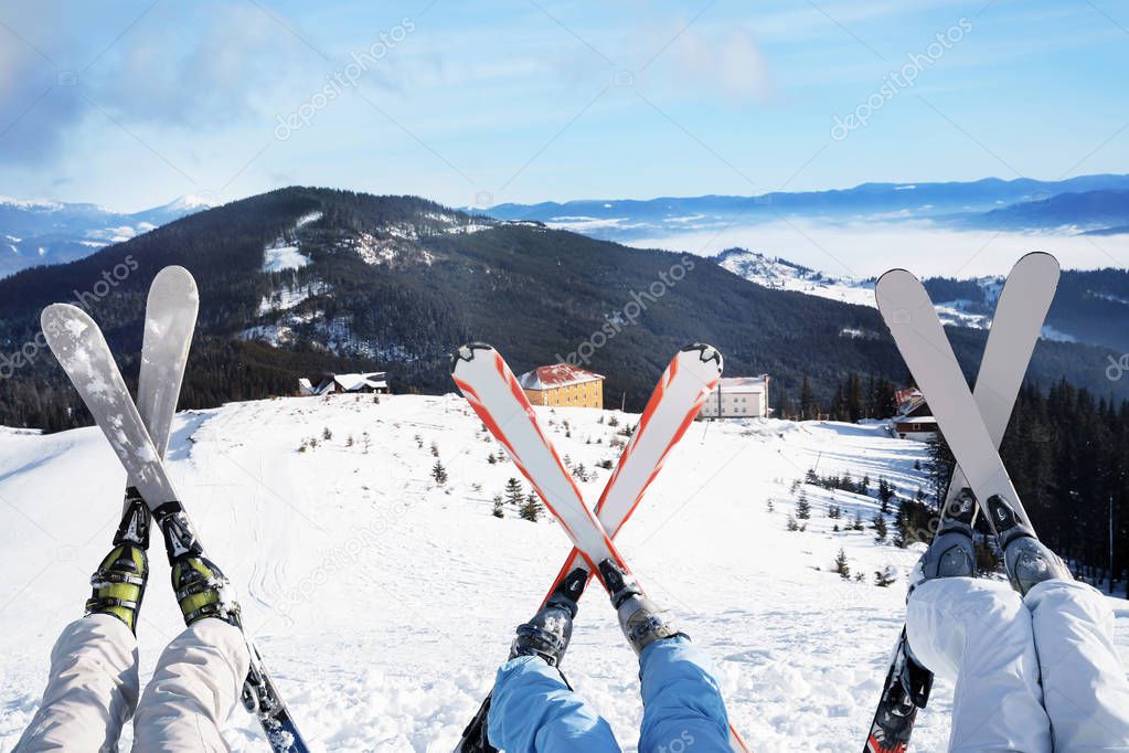 Friends having fun on ski piste at snowy resort. Winter vacation