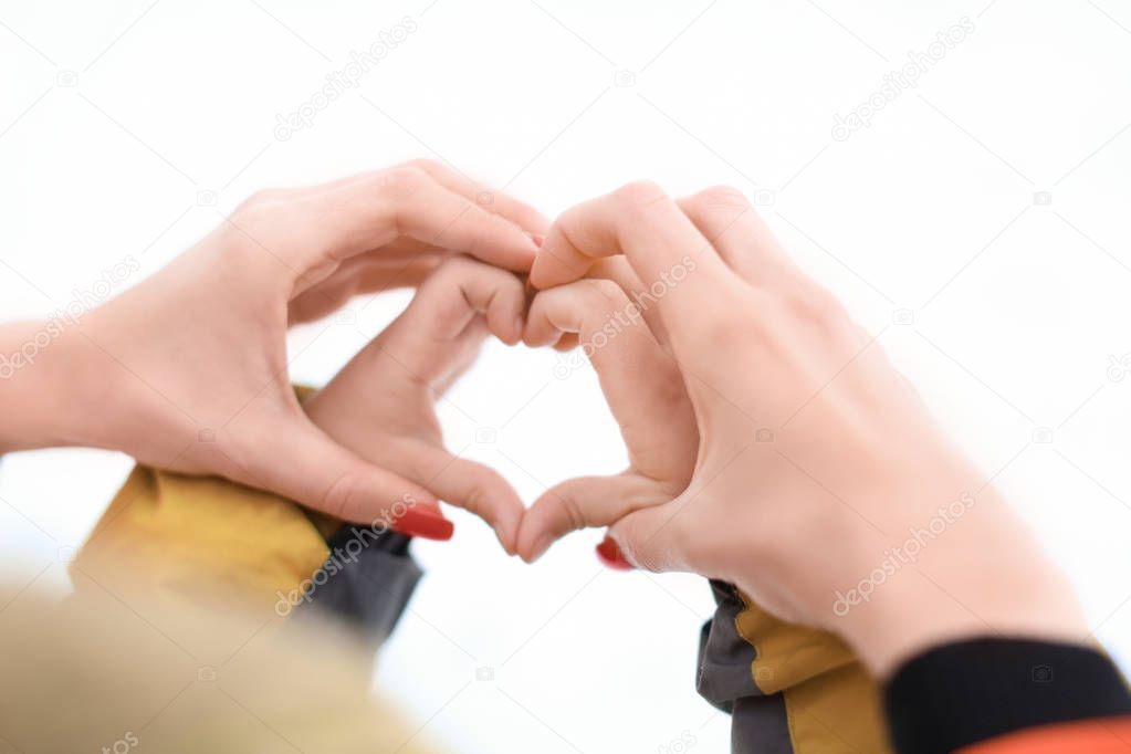 Mother and child making heart symbol 