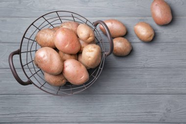 Sepeti ahşap masa üzerinde taze Çiğ patates ile
