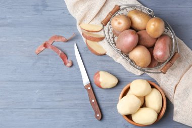 Sepet ve ahşap masa üzerinde taze Çiğ patates ile kase