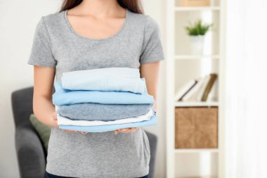 Temiz elbise yığını kapalı tutan kadın. Çamaşır günü