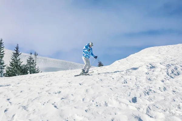 Homem esquiando em pista no resort nevado. Férias inverno — Fotografia de Stock