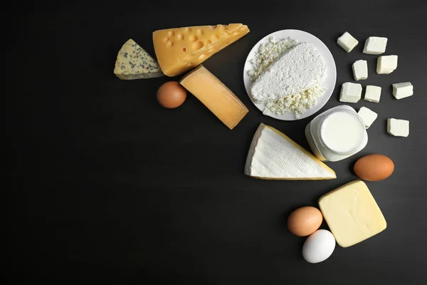 Fresh dairy products and eggs on black background