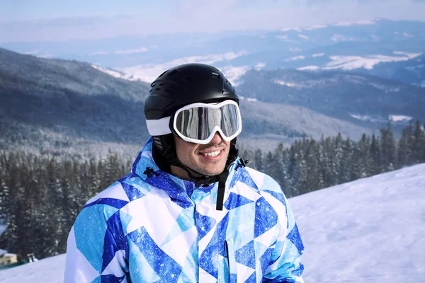 Happy sportsman on ski piste at snowy resort. Winter vacation — Stock Photo, Image