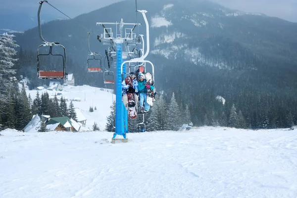 Couple on ski lift at mountain resort. Winter vacation — Stock Photo, Image