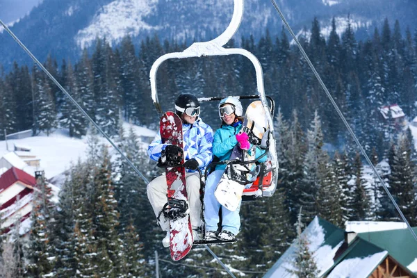 Couple on ski lift at mountain resort. Winter vacation — Stock Photo, Image