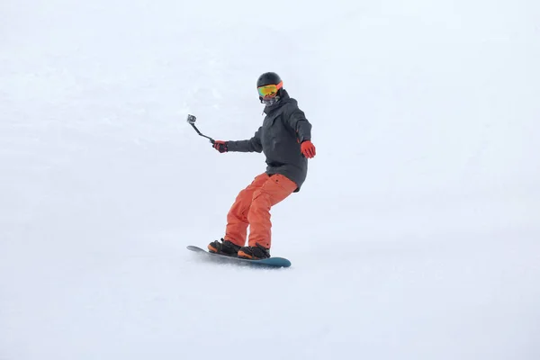 Snowboarder op de skipiste in het besneeuwde resort. Wintervakantie — Stockfoto