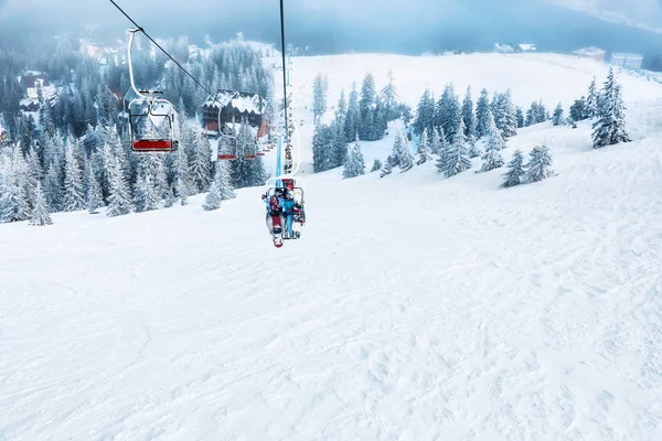 Couple on ski lift at mountain resort. Winter vacation — Stock Photo, Image