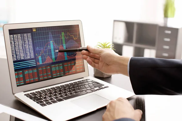 在屏幕上使用笔记本电脑和股票图表数据的人 — 图库照片
