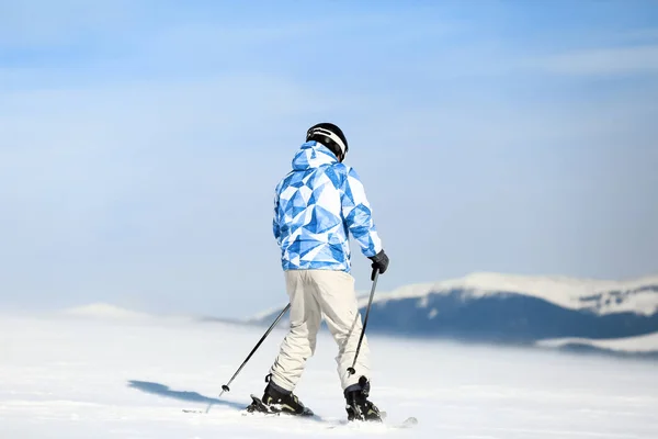 Homem esquiando em pista no resort nevado. Férias inverno — Fotografia de Stock