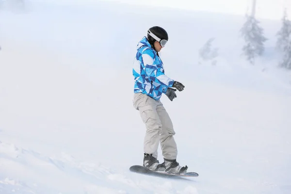 Snowboarder en pista de esquí en estación nevada. Vacaciones de invierno —  Fotos de Stock