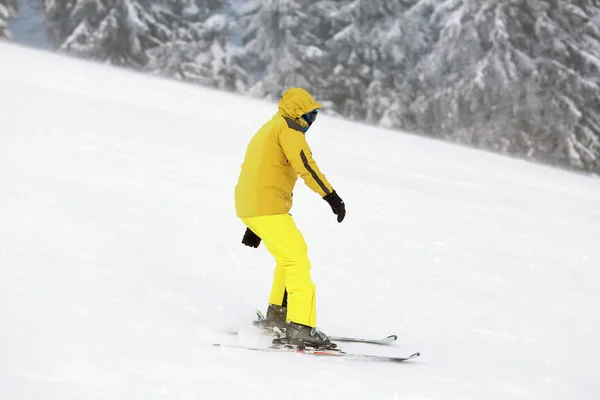 Homem esquiando downhill no resort nevado. Férias inverno — Fotografia de Stock