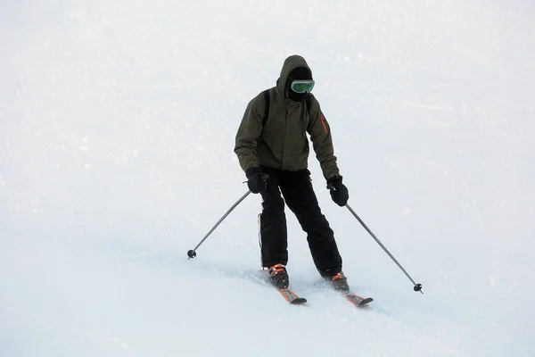 Hombre esquiando en la estación nevada. Vacaciones de invierno — Foto de Stock