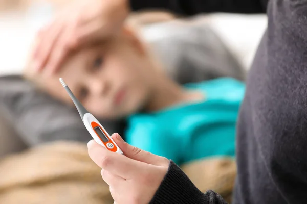 Pai medir a temperatura de sua filha doente em casa — Fotografia de Stock